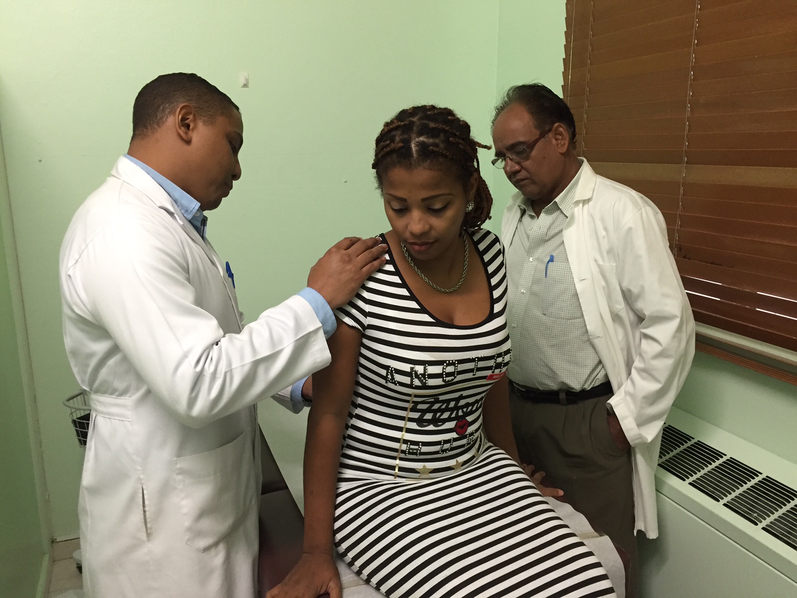 Los neurocirujanos Kelvin Del Villar y Walí Rahman realizan una consulta postoperatoria a la paciente luego de la cirugia