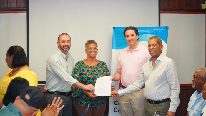 Jorge Sturla, Eduardo Martínez Lima and Eladio Uribe give Eunice Magra the contract of ownership of the house donated by Central Romana.